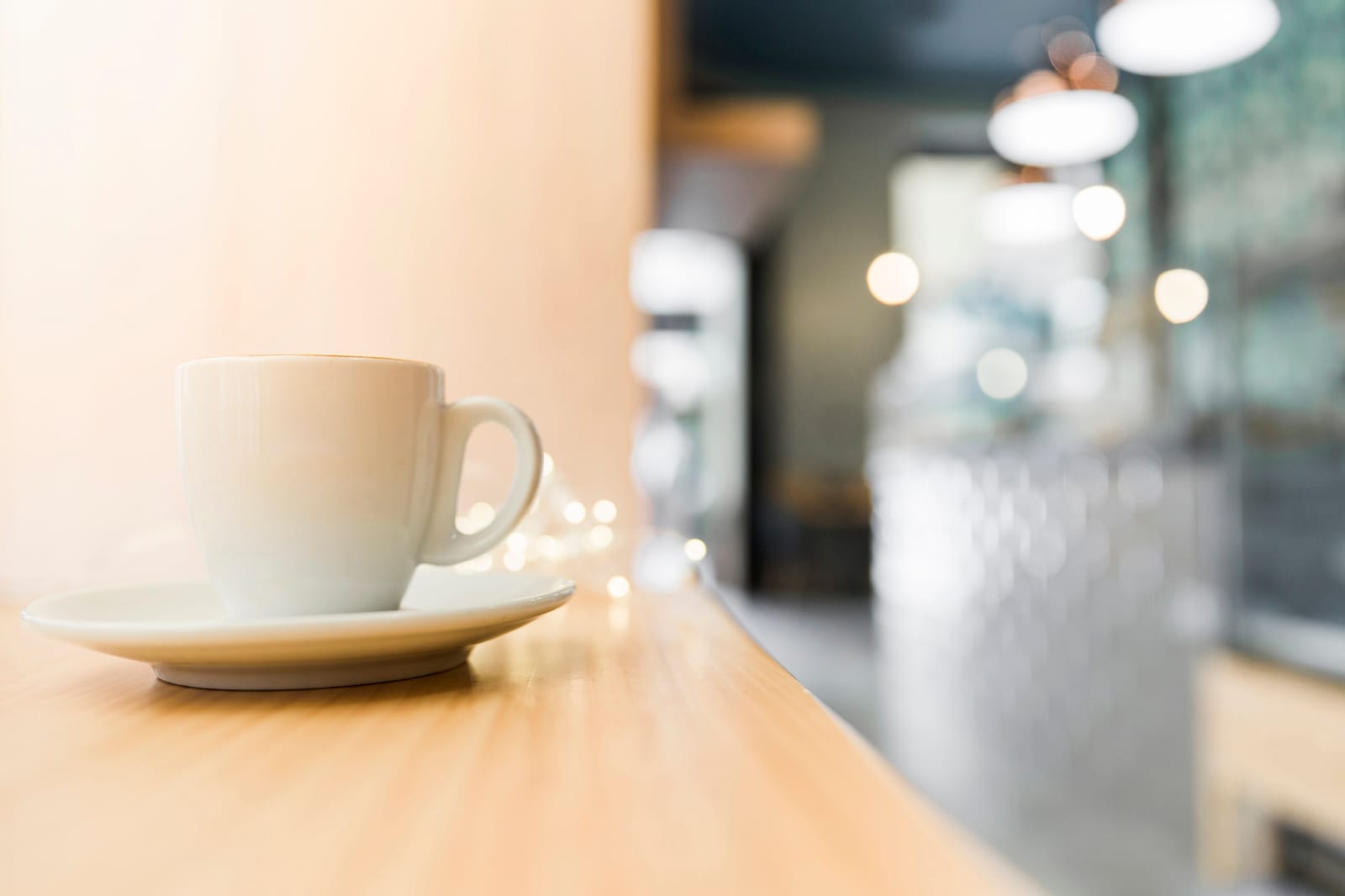 Xícara de café sobre mesa de madeira em ambiente de café